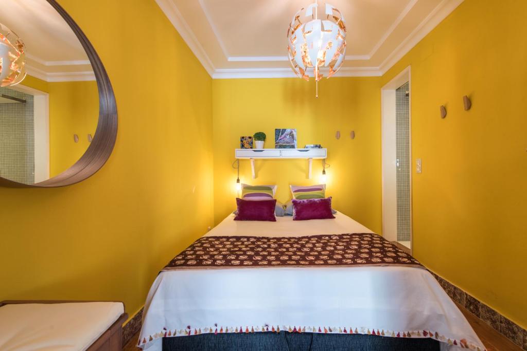リスボンにあるCozy Apartment in historic centerの黄色のベッドルーム(鏡付きベッド付)