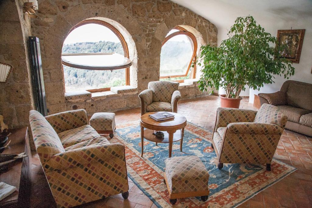 - un salon avec des chaises et une table dans l'établissement La Casa Degli Archi, à Pitigliano
