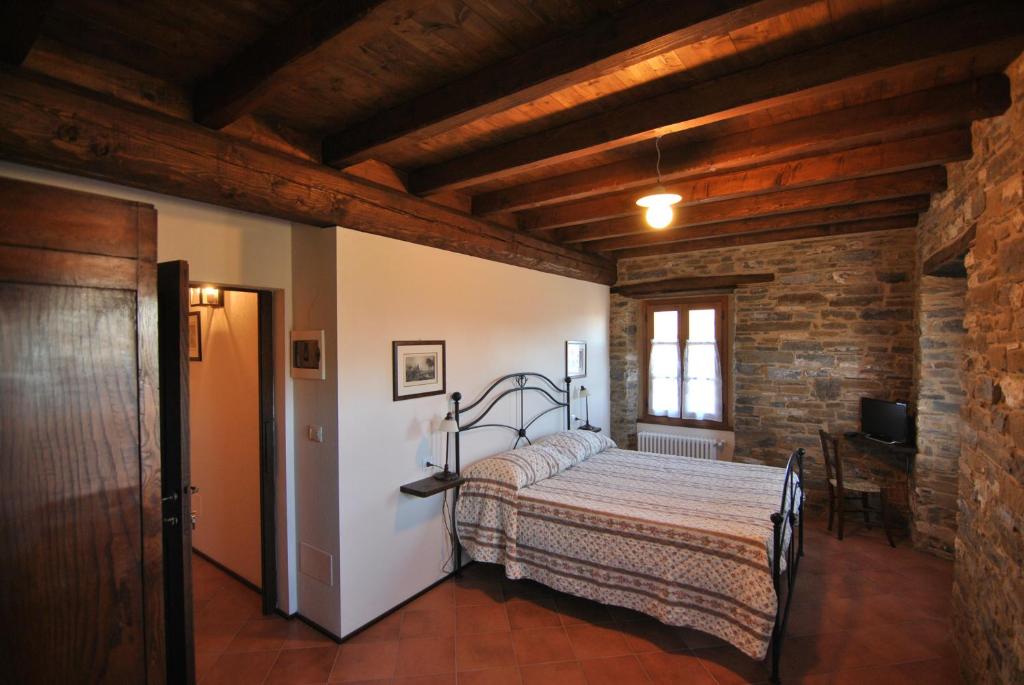 ベルチェートにあるOspitalita' Rurale Casa Caniの木製の天井の客室で、ベッドルーム1室(ベッド1台付)