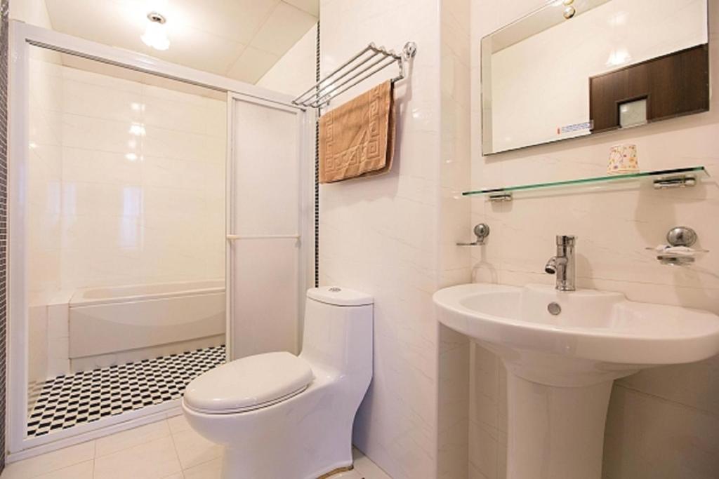 台東市的住宿－百分百民宿，白色的浴室设有卫生间和水槽。