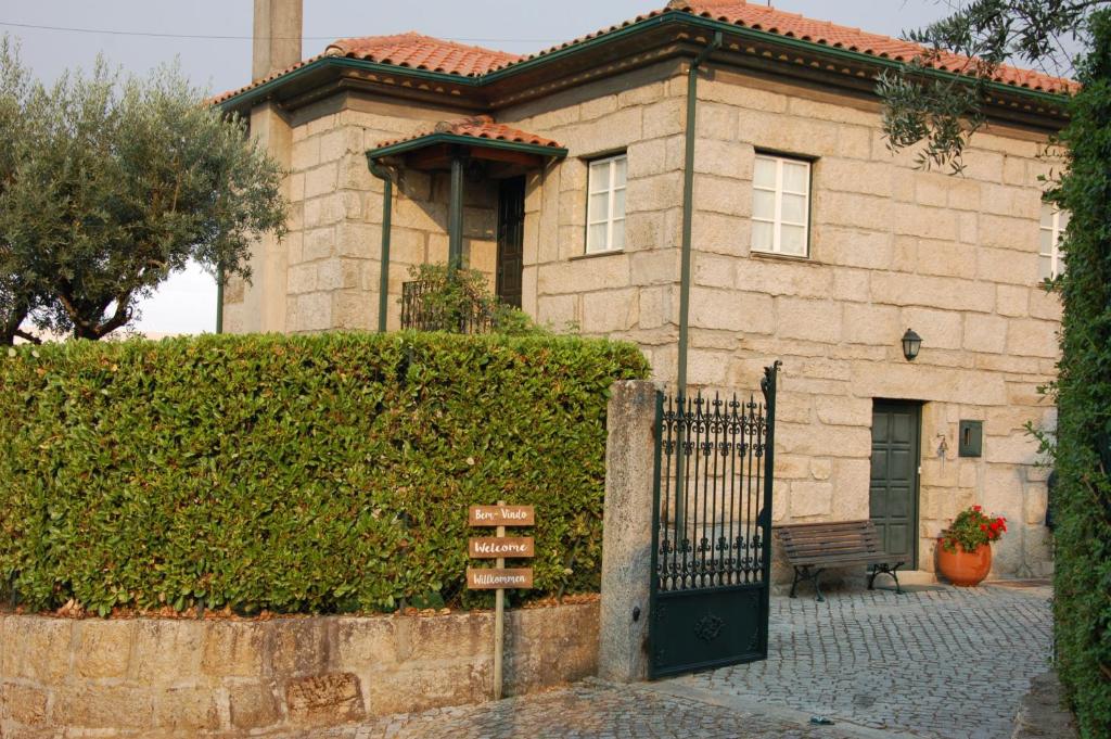 ein Backsteinhaus mit einem Tor davor in der Unterkunft A Casa da Celeste in Fagilde