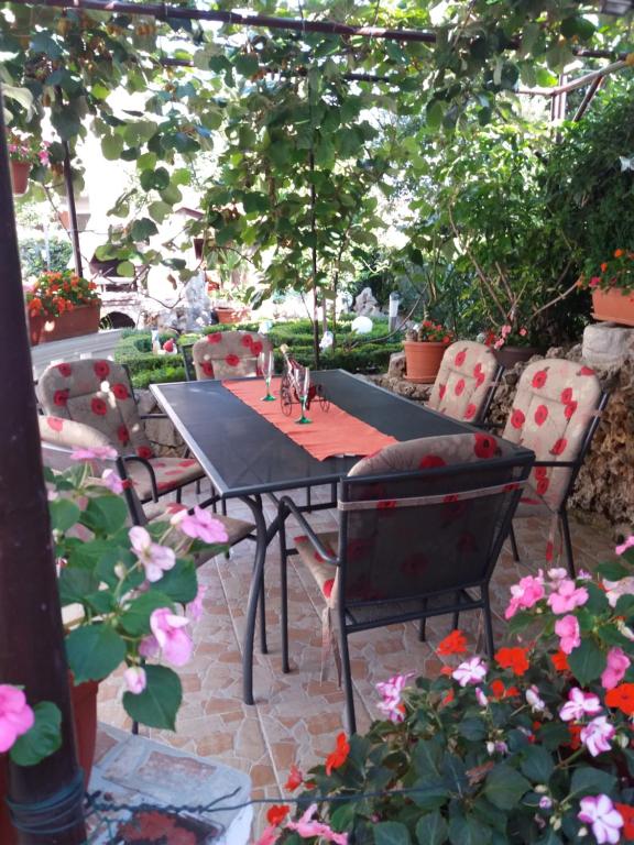 a table and chairs on a patio with flowers at Colic in Crikvenica