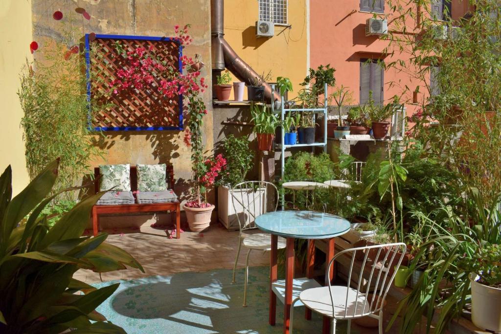 un patio con tavolo, sedie e piante di Babbo Guest House a Roma