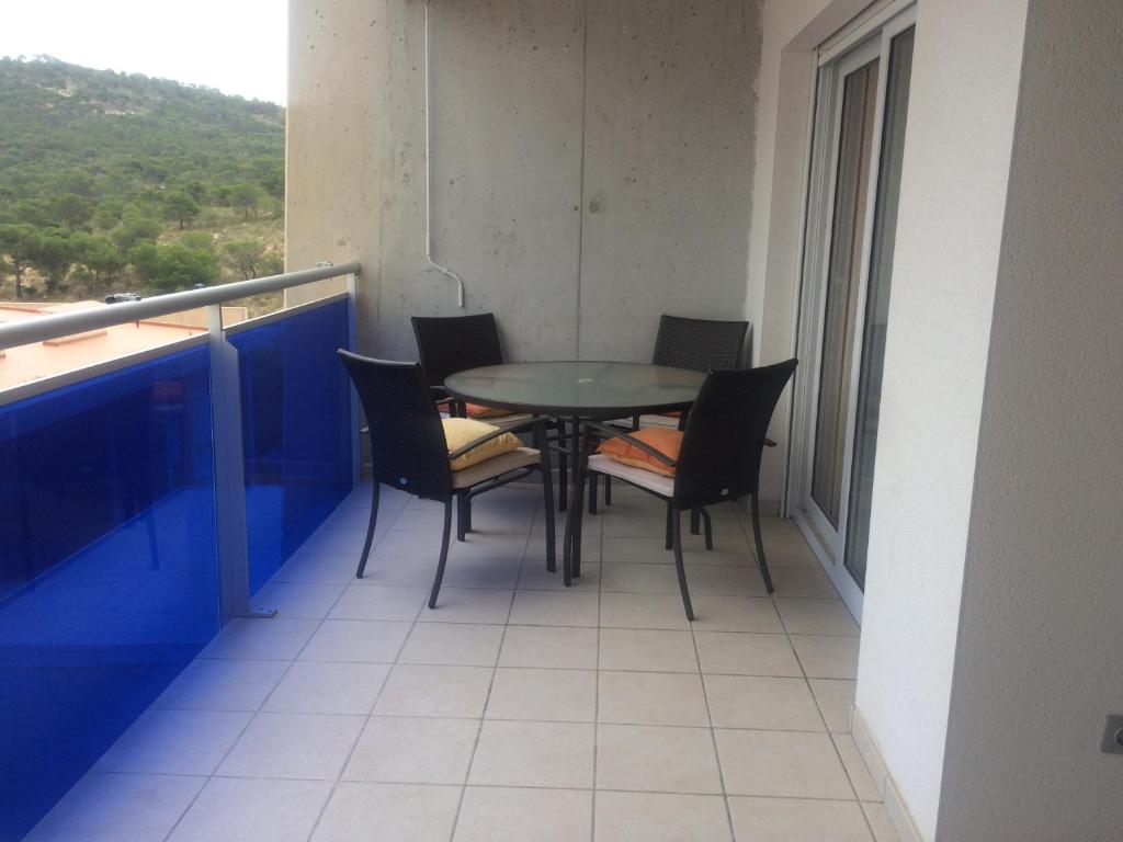 ビリャホヨサにあるApartamento En La Cala De Villajoyosaの建物のバルコニーにテーブルと椅子