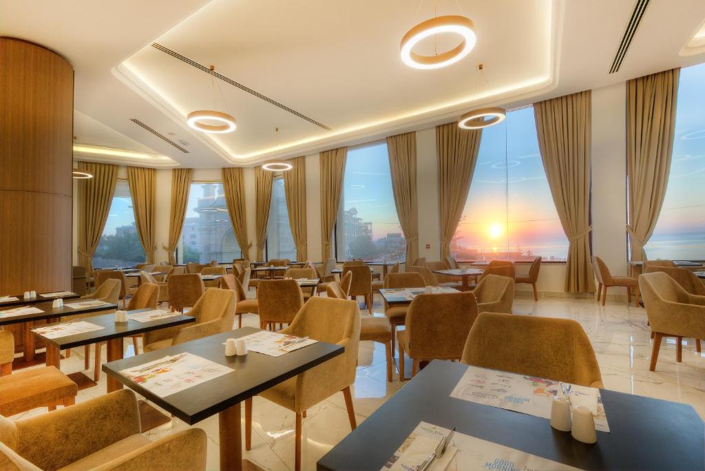 a restaurant with tables and chairs with a view at Vivaldi Hotel in St. Julianʼs