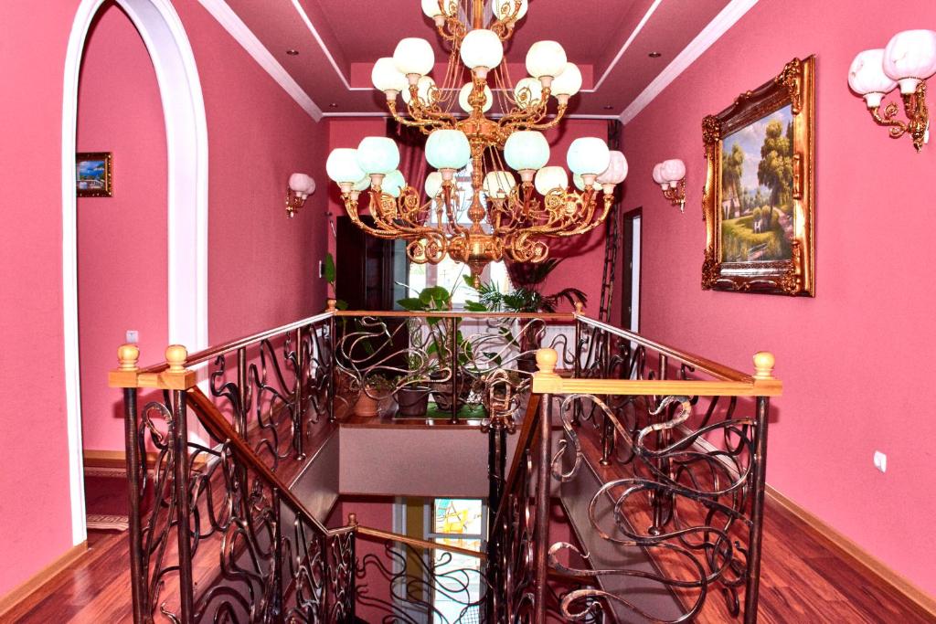 a pink room with a staircase with a chandelier at Hotel Art-Seg in Akhalk'alak'i