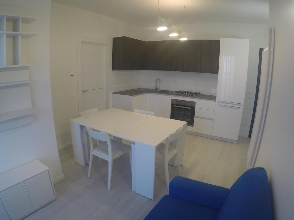 カオルレにあるCenter New Deluxe Apartaments Con Balcone Vista Mareのキッチン(白いテーブル、青い椅子付)