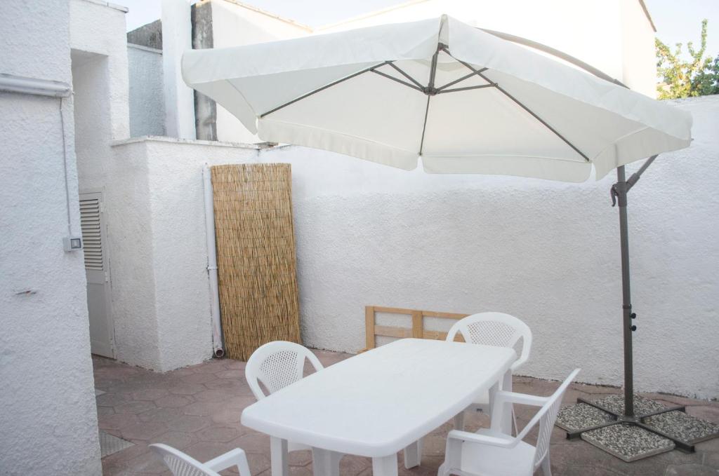 アヴェトラーナにあるWhite Salentoの白いテーブルと椅子、傘