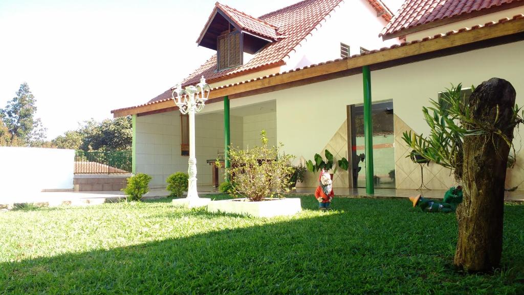 uma casa com um jardim verde com uma casa em Pousada Sao Judas Tadeu em Guaratinguetá