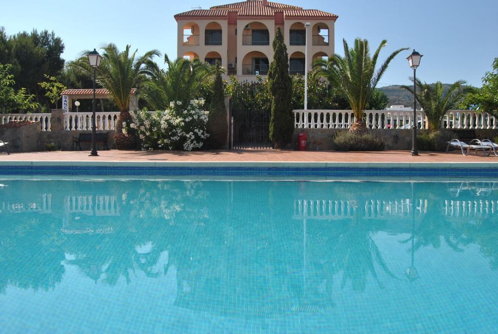 uma piscina com um edifício ao fundo em Hotel Sancho III em Alcossebre