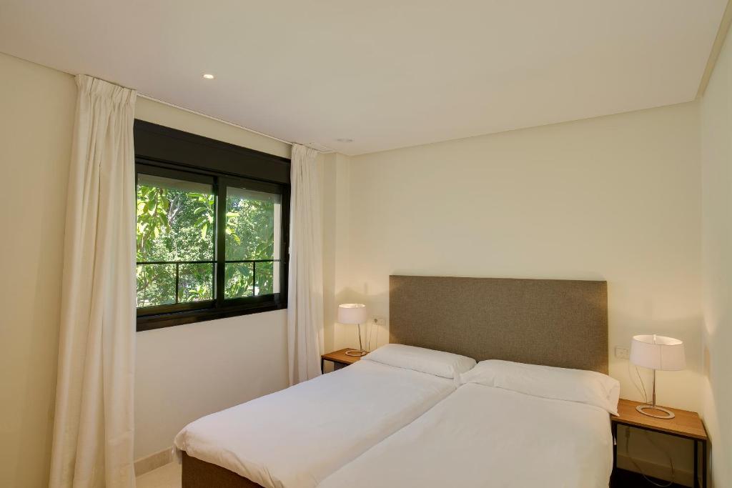 A bed or beds in a room at Mimosas Suites Banús