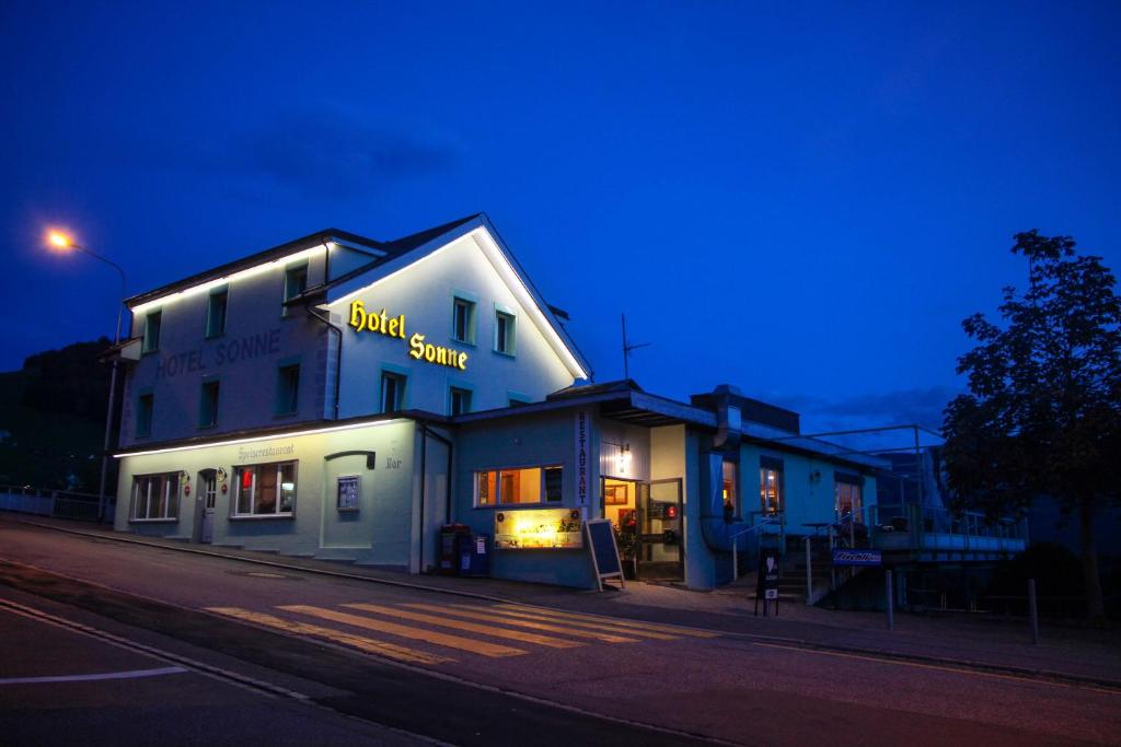 a building with a sign that reads bird sauce at night at Hotel Sonne in Amden