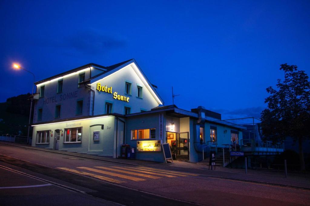 アムデンにあるHotel Sonneの夜の鳥のソースを読む看板のある建物