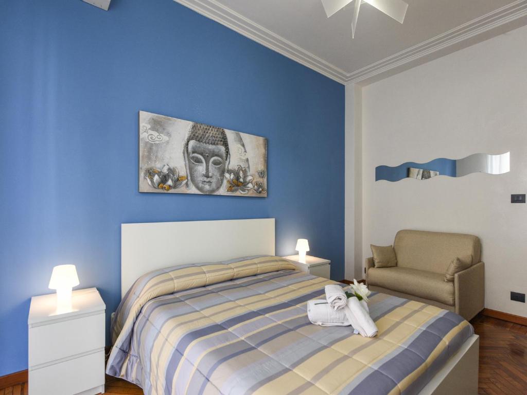 トリノにあるLa Favola Apartmentの青いベッドルーム(ベッド1台、椅子付)
