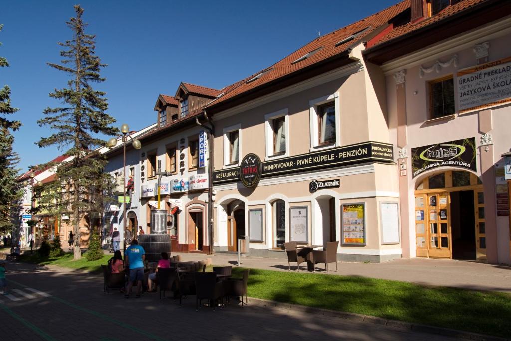 grupa ludzi siedzących przed budynkiem w obiekcie Penzión Minipivovar Tatras w Popradzie
