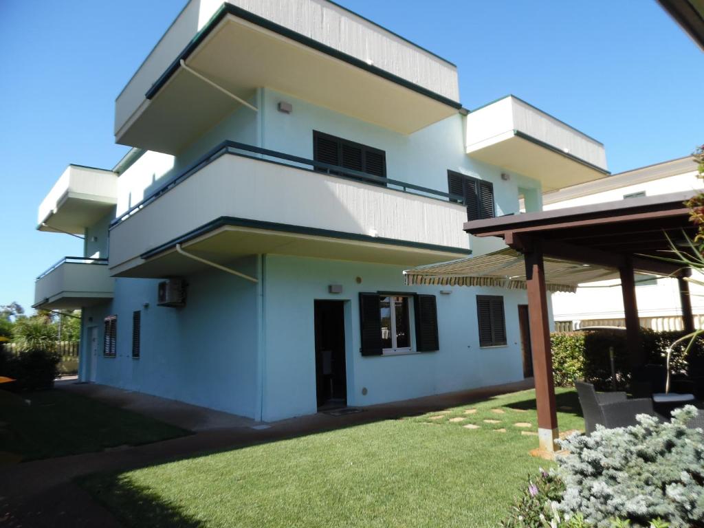 a white building with a lawn in front of it at Acquamarina B&B in Martinsicuro