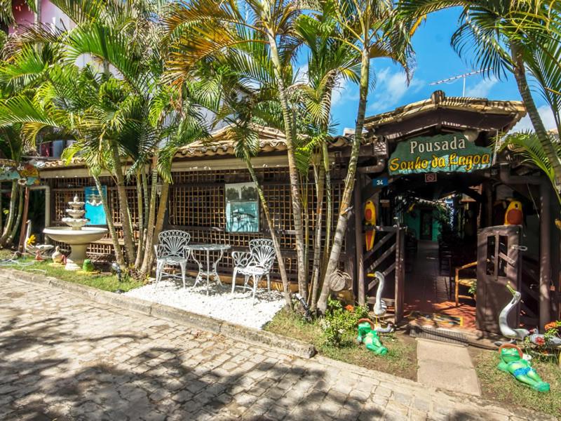 a restaurant with palm trees in front of a building at Pousada Sonho da Lagoa in Praia do Forte