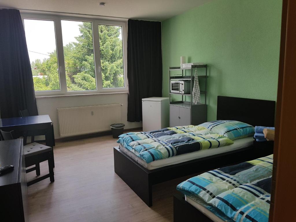 a bedroom with two beds and a microwave in it at Pension zum Bauhof in Zwickau
