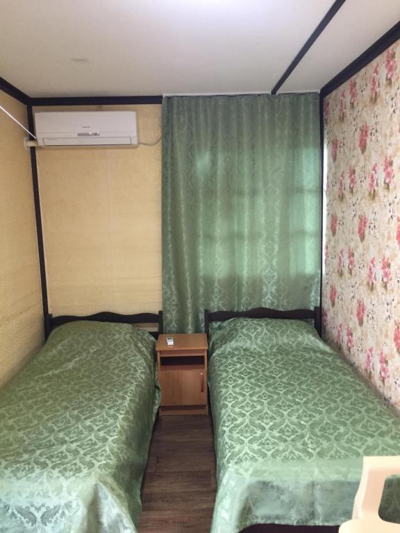 ラザレフスコエにあるFazenda Guest houseの小さな部屋のベッド2台 緑のシーツ付