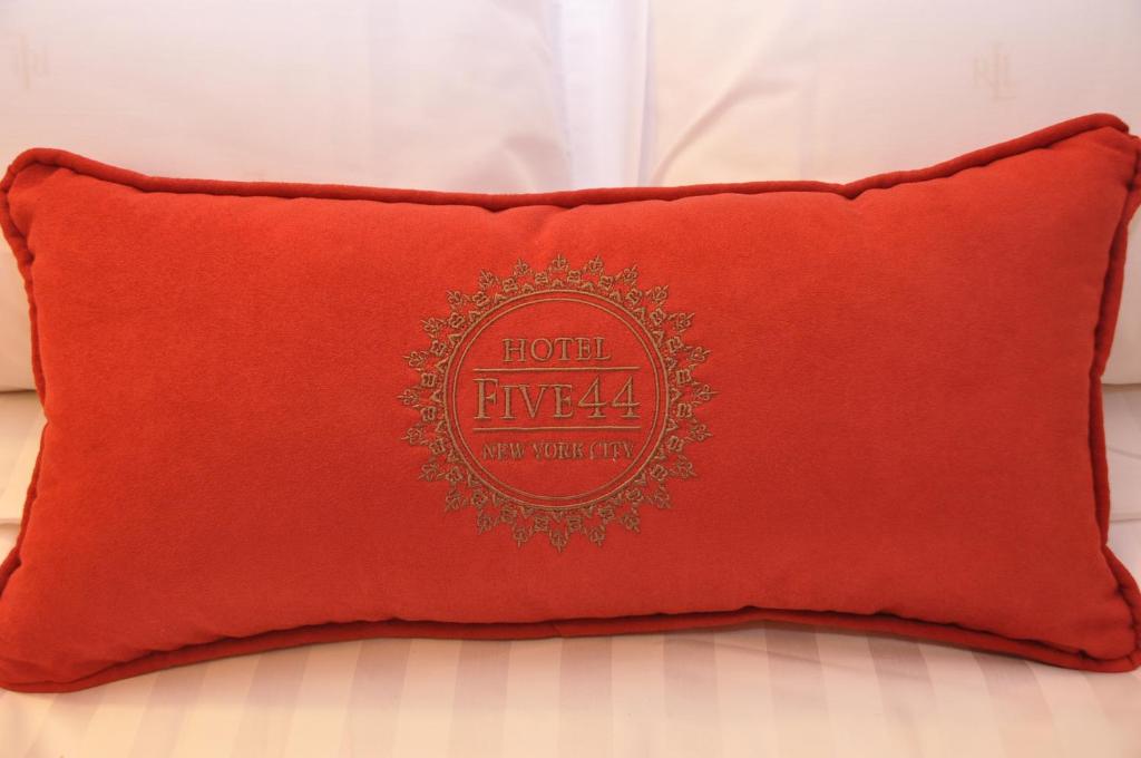 un oreiller rouge posé sur un lit dans l'établissement Hotel Five44, à New York