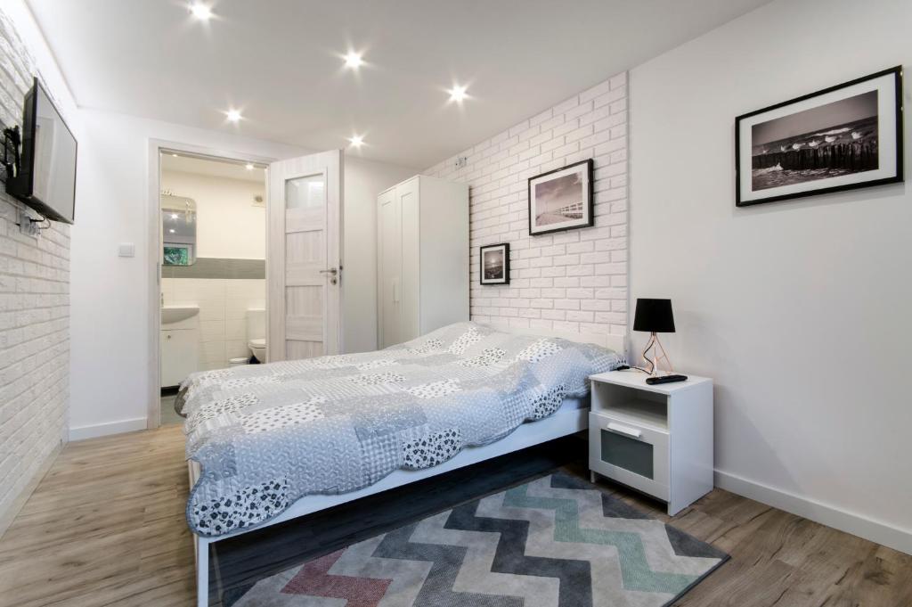 a bedroom with a bed and a white brick wall at Sopot Sopot Studio in Sopot