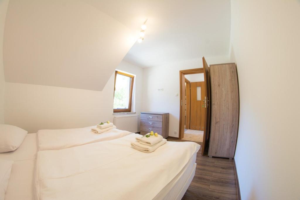 - une chambre avec 2 lits et des serviettes dans l'établissement Apartamenty z Ogrodem, à Szczawnica