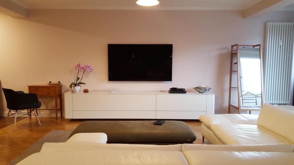 Bremen Apartments Nath في بريمين: غرفة معيشة مع أريكة وتلفزيون بشاشة مسطحة