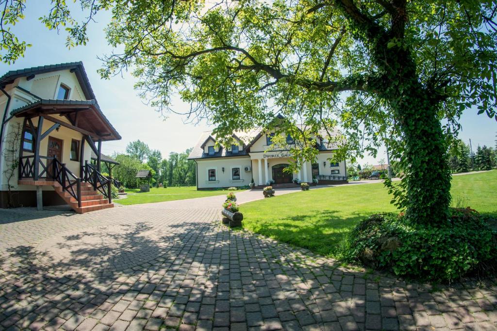 une maison avec un arbre et une allée en briques dans l'établissement Agroturystyka Oświęcim, à Skidzin