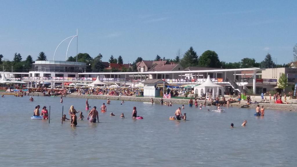 a group of people in the water at a beach at Judit nyaraló in Velence
