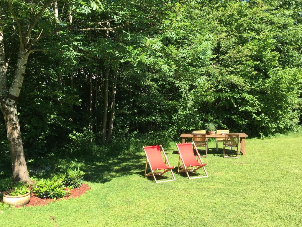 a table and chairs in a yard with trees at Chalet Tirolia in Kirchdorf in Tirol