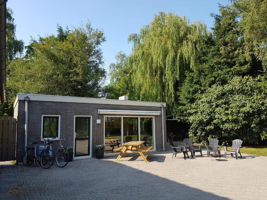 un edificio con sillas, mesa y mesa de picnic en Guest House Ons Hoekje en Houten