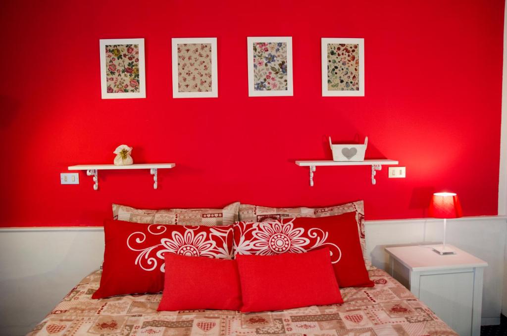 ヴァル・ディ・ゾルドにあるAlbergo al Soleの赤い壁のベッドルーム1室、ベッド1台(赤い枕付)