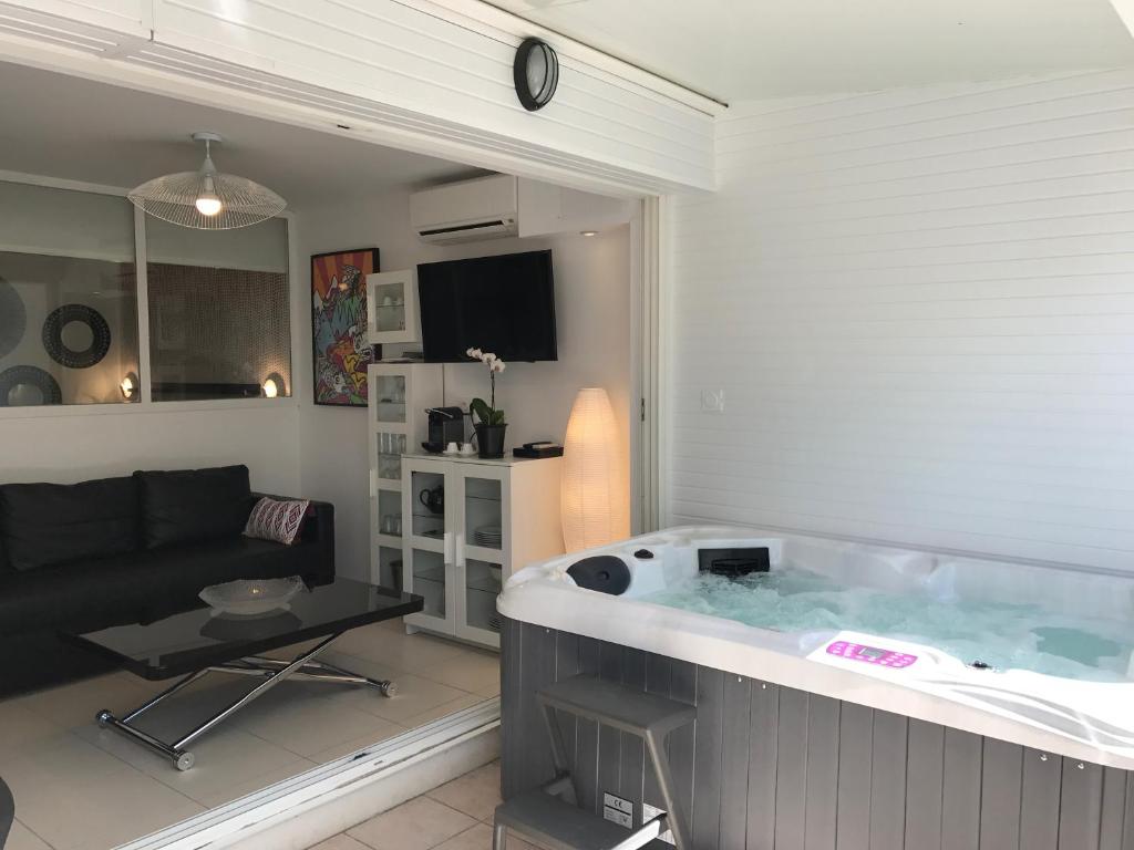a large tub in a living room with a couch at Cap Locations Naturisme in Cap d'Agde