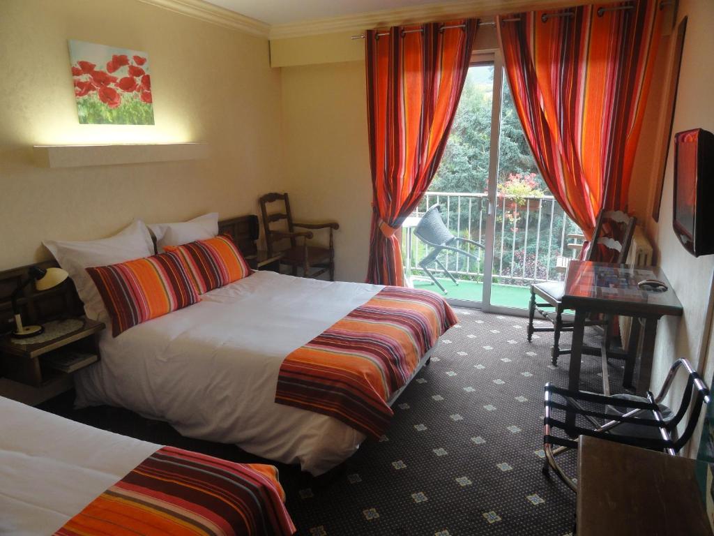 Habitación de hotel con 2 camas y balcón en Le Jardin, en Saillagouse