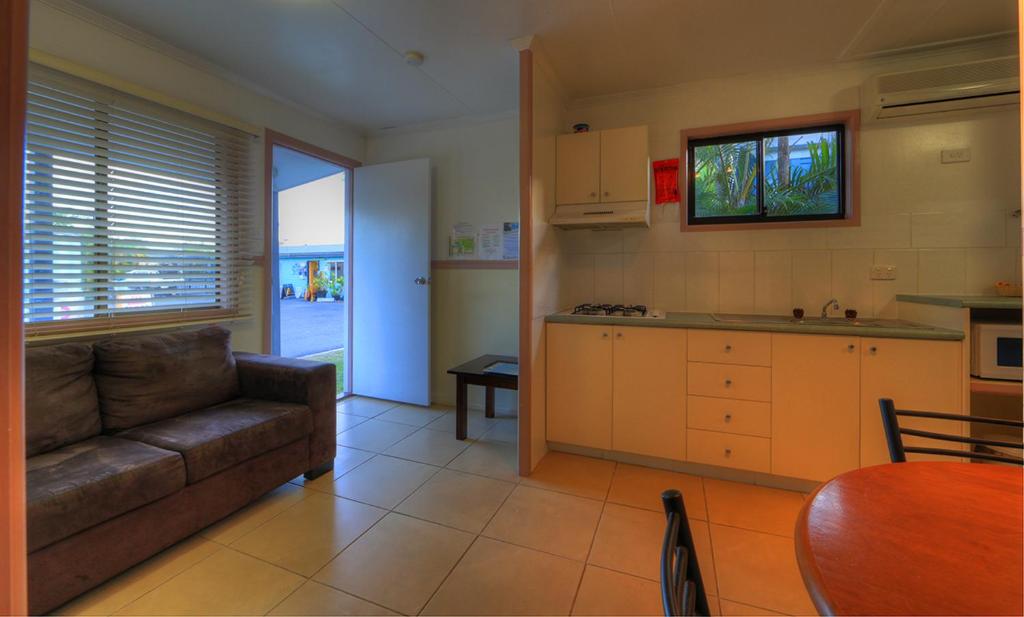 a living room with a couch and a kitchen at Kurrimine Beach Holiday Park in Kurrimine Beach