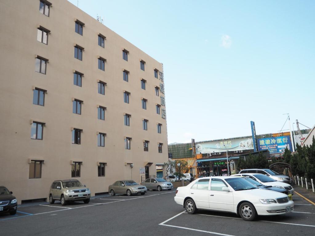 a parking lot with cars parked in front of a building at The Riverside Hotel Hengchun in Hengchun South Gate