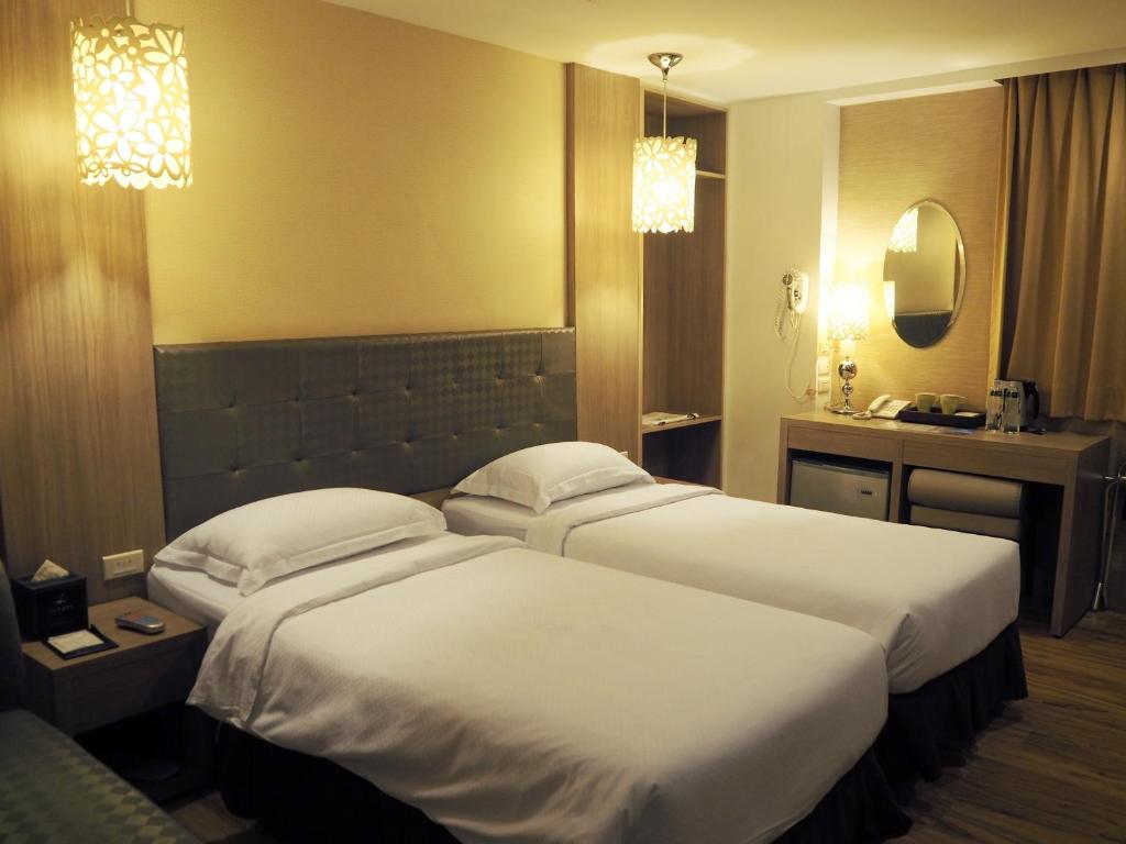 a hotel room with two beds and a sink at The Riverside Hotel Hengchun in Hengchun South Gate
