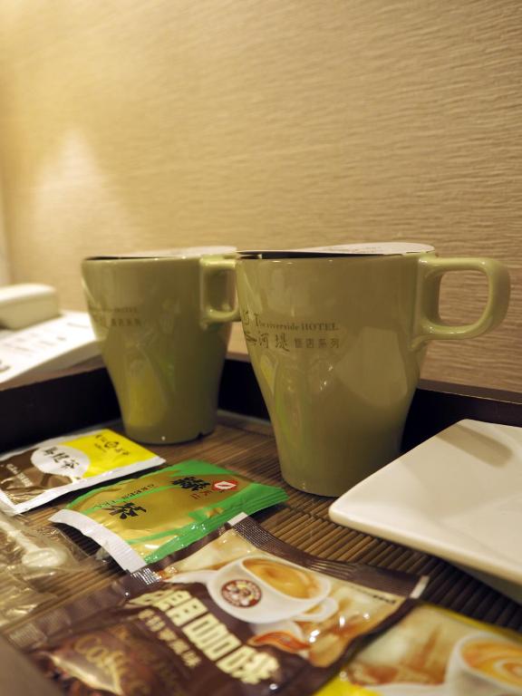 two cups sitting on a table next to a laptop at The Riverside Hotel Hengchun in Hengchun South Gate