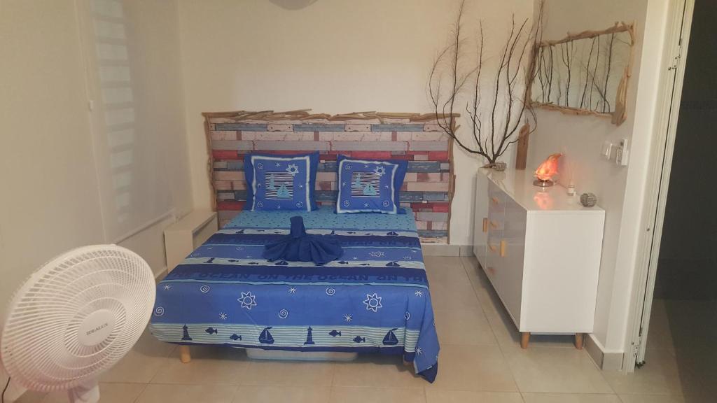 a bedroom with a blue bed with blue pillows at Villa Taho in Terre-de-Haut
