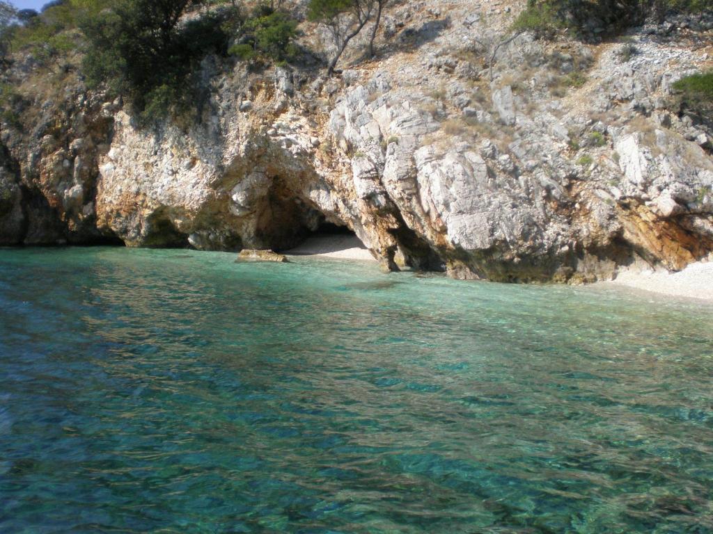 a beach with a cave in the middle of the water at Guest House Renata in Plomin