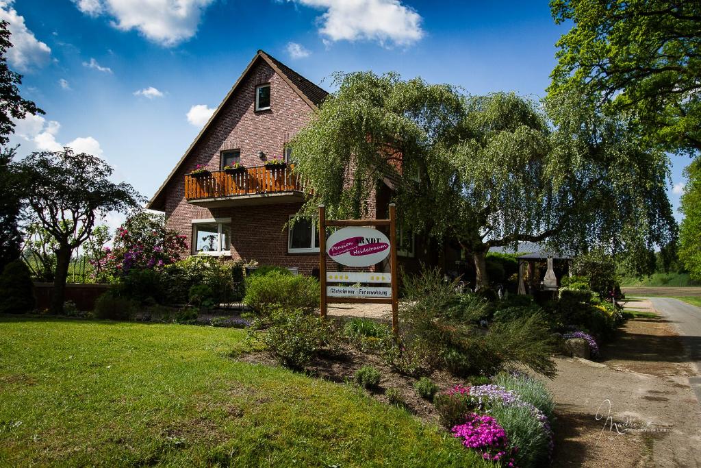 una casa con un cartel delante de ella en Heidetraum Pension & Ferienwohnung Arndt, en Bispingen