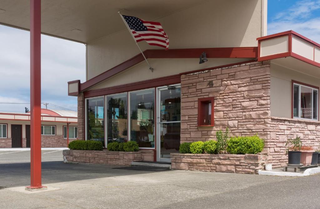 an american flag flying in front of a store at Flagstone Motel in Port Angeles