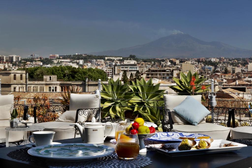 - une table avec de la nourriture et une vue sur la ville dans l'établissement Palace Catania | UNA Esperienze, à Catane