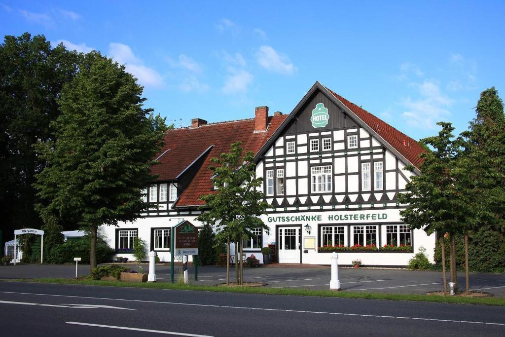 a black and white building on the side of a road at Gutsschänke Holsterfeld in Salzbergen