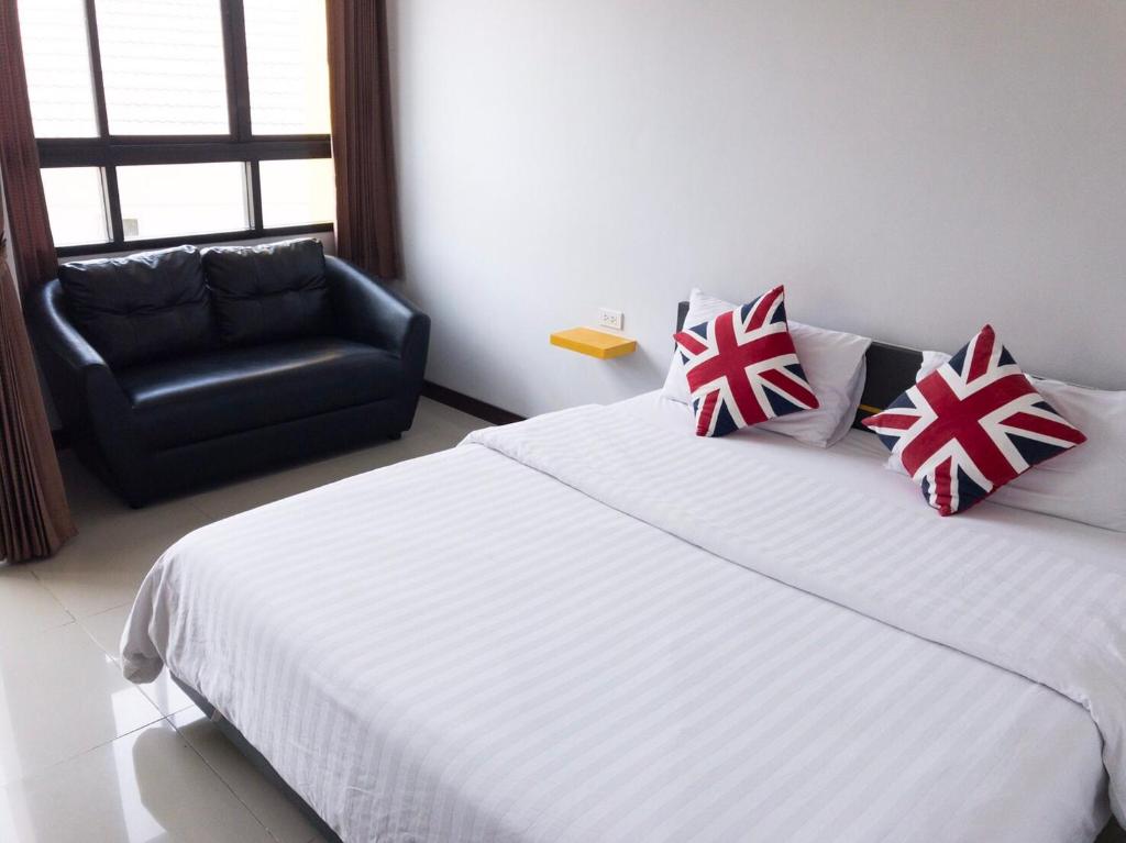 1 dormitorio con 1 cama y 1 silla negra en The Icon service apartment en Si Maha Phot