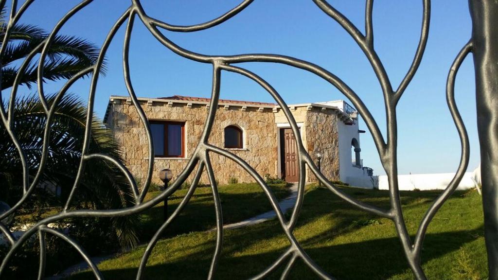 ein Haus, das durch die Äste einer Palme gesehen wird in der Unterkunft Relax al Mare in Olbia