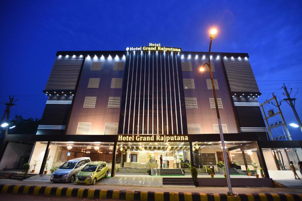 un edificio con coches estacionados frente a él en Hotel Grand Rajputana en Raipur