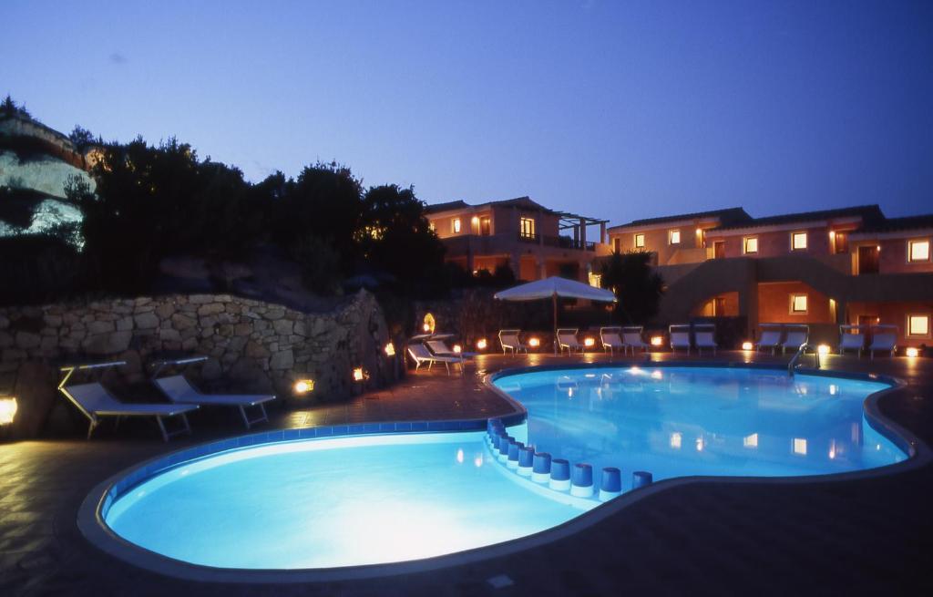 a large swimming pool at night with lights at Hotel Stelle Marine in Cannigione