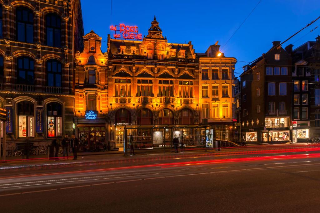 een verlicht gebouw in een stadsstraat 's nachts bij Hotel Die Port van Cleve in Amsterdam