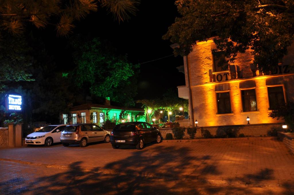 un grupo de autos estacionados al lado de un edificio por la noche en Yıldız Hotel, en Ürgüp